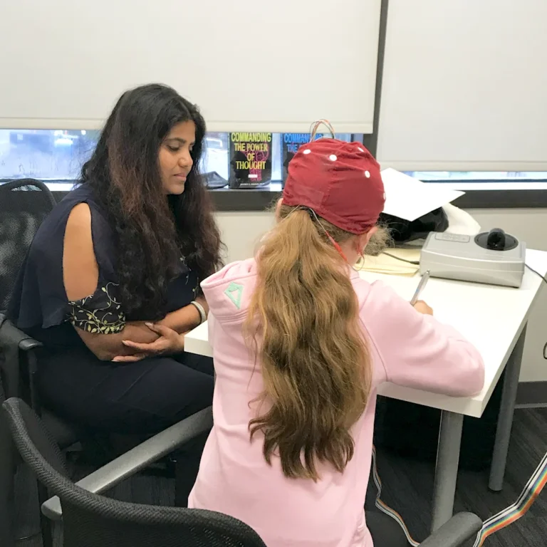 Kohila Sivas working with a student wearing an EEG cap